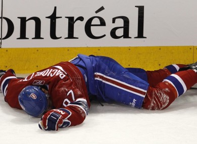 Montreal Canadiens' Max Pacioretty lies on the ice after taking a hit by Boston Bruins' Zdeno Chara.