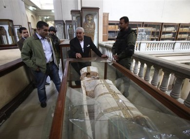 Zahi Hawass standing near the broken vitrine containing the damaged New Kingdom coffin.