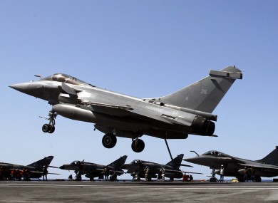 A fighter lands after a mission over Libya on France's Charles de Gaulle aircraft carrier