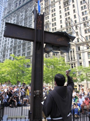 Rev. Brian Jordan sprinkles water on the Ground Zero cross during a ceremony in July. American Atheists has filed a lawsuit asking for its removal.
