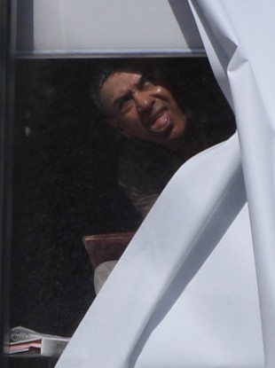 A man believed to be holding a child hostage at a lawyers office looks out a window in suburban Sydney.