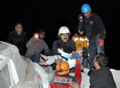 A child is pulled alive from the wreckage.
