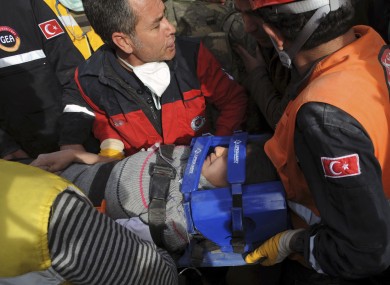 Workers carry a rescued youth from a building in Ercis