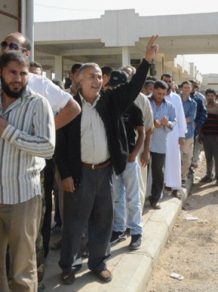 People stand in line to see the body of former Libyan leader Muammar Gaddafi outside a refrigeration room where his body is being kept in the suburbs of Misrata.