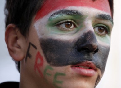 A protestor carries a banner at an anti-regime rally near the Syrian embassay in Cairo, Egypt.