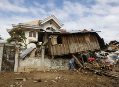 19 December: Locals retrieve items from their house which landed on a fence during Typhoon Washi in Iligan city, Philippines. .