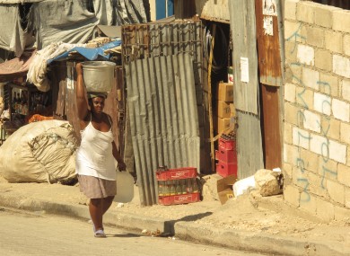 A woman carries a large pot in Baillergeau temporary camp in Haiti