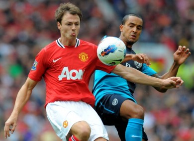 Jonny Evans tussles with Theo Walcott.