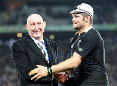 New Zealand All Black captain Richie McCaw is honored with his 100th cap as he shakes hands with former player Jock Hobbs last year.
