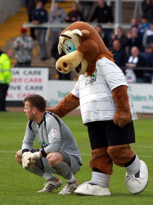 Hereford goalkeeper is comforted by the club mascot after their relegation.