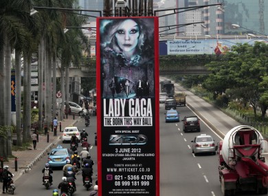 Motorists ride past a promotional banner for US singer Lady Gaga's Born This Way Ball Asia Tour in Jakarta, Indonesia