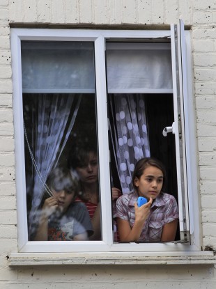 Children watch from their window during riots in Hackney, east London.