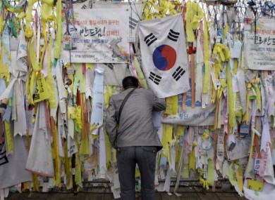 A man looks at the North side through the barbed wire fence decorated with messages wishing for the reunification of the Koreas near the border village of Panmunjom.