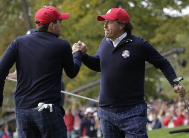 USA's Keegan Bradley congratulates Phil Mickelson after Mickelson made a putt to win the 13th hole.