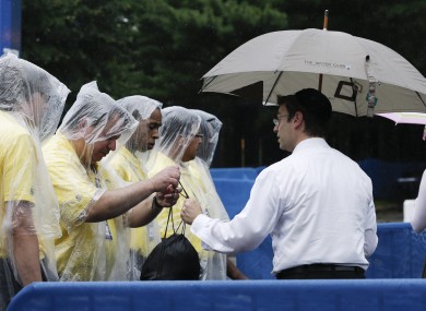 Security checks the bag of a tennis fan arriving during a rain delay in the fourth round of play.