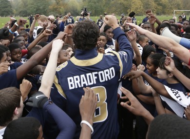 St. Louis Rams quarterback Sam Bradford reacts with school children as he takes part in a NFL organised coaching session for some London schoolchildren in Regents Park.