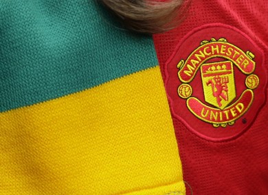 A Manchester United supporter is seen with a scarf in the colours of the anti-Glazer movement.