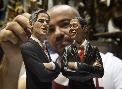 Italian Nativity scenes designer Genny Di Virgilio puts the final touches on two statuettes depicting President Barack Obama, right, and Republican rival Mitt Romney in his shop in Naples, Italy,