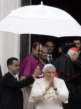 The pope's former butler Paolo Gabriele, at left holding umbrella.