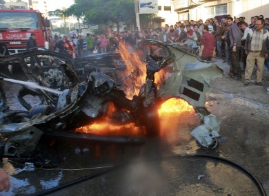 People look at a wreckage of the car in which Ahmed Jabari, head of the Hamas military wing in Gaza City, was killed.