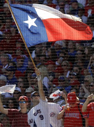 A fan of the Texas Rangers baseball team waves the state flag.