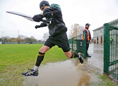 Linesman Diarmuid Kirwan clears a puddle on his way back out for the second half of the Dr Crokes game.