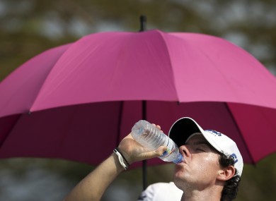 Rory McIlroy takes a drink to cool off during the first round of the Singapore Open.