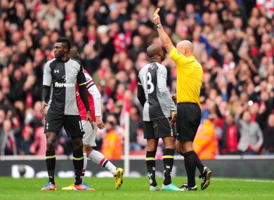 Tottenham Hotspur's Emmanuel Adebayor (l) is shown a straight red for a dangerous tackle on Arsenal's Santi Cazorla.