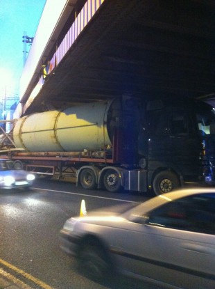 The truck stuck under the bridge
