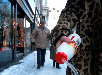 A woman fights the icy footpaths with salt in central Dublin in December 2010.