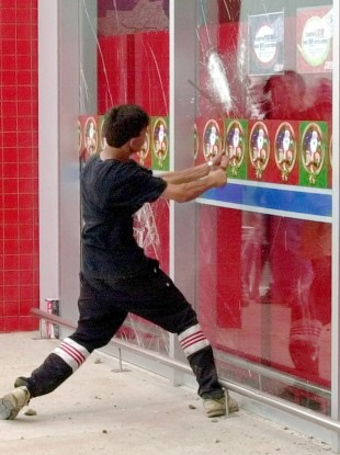 A man tries to break the windows of a supermarket in Buenos Aires earlier this week.