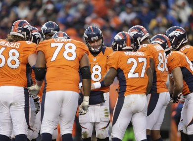 The Denver Broncos offense huddles around quarterback Peyton Manning.