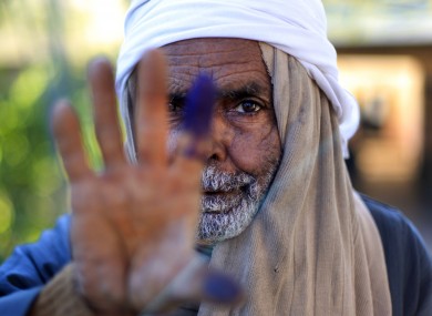 An Egyptian elderly man shows his inked finger after casting his vote on the second round of a referendum on a disputed constitution drafted by Islamist supporters of President Mohammed Morsi in Fayoum
