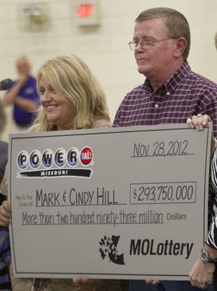 Cindy and Mark Hill hold a check for having one of two winning Powerball tickets during an announcement in Dearborn, Missouri.