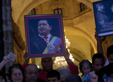 A man holds a framed image of Chavez after attending a mass to pray for the Venezuelan president's recovery