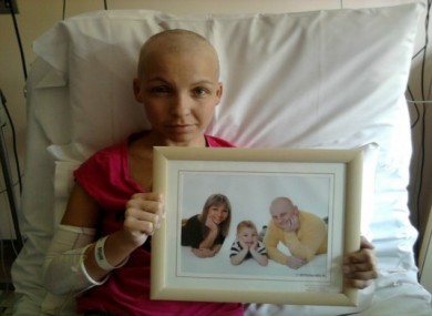Marta Salacka in her hospital bed holding a picture of her family.