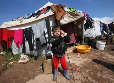 A Syrian refugee boy stands outside his tent at Atmeh refugee camp, in the northern Syrian province of Idlib.