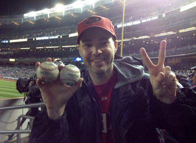Zack Hample, a 35-year-old New Yorker holds the two balls he caught in the right-field seats.