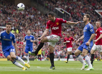Manchester United's Robin van Persie, centre, fires the ball against Chelsea's Cesar Azpilicueta, left, as Chelsea's Branislav Ivanovic, second right, looks on during their English Premier League soccer match.