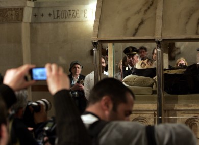 Pilgrims photograph the body of Padre Pio lying in repose inside a casket in a church in Italy in 2008