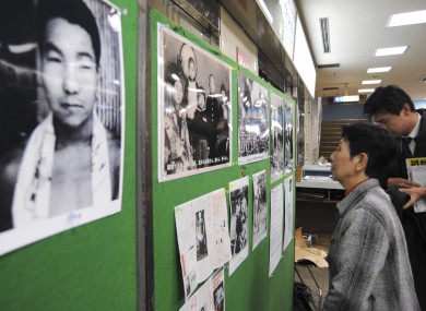 Hideko Hakamada, sister of death row inmate Iwao Hakamada,looking at family photos in 2008 during a campaign to have him freed. Iwao is in the pic on left.