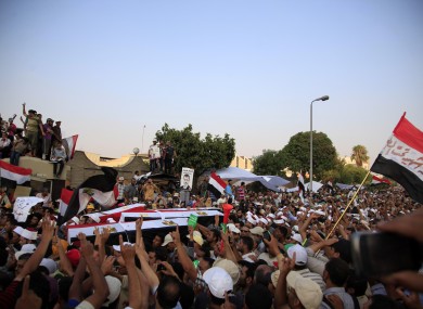 Supporters of Egypt's ousted President Mohammed Morsi carry coffins, covered with the national flag, of four men killed after Egyptian troops opened fire on mostly Islamist protesters marching on a Republican Guard headquarters Friday, in Cairo.