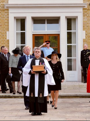 Reverend Richard Whittington carries an oak casket with the ashes of the former leader, followed by Thatcher's son Mark and his wife Sarah