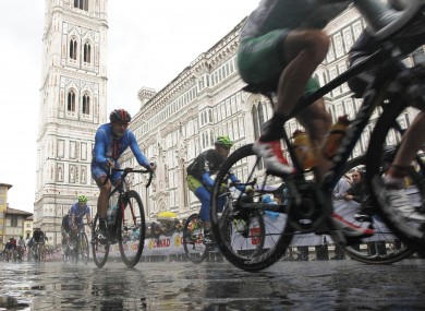 Cyclists ride past the Santa Maria del Fiore Basilica in Florence today.