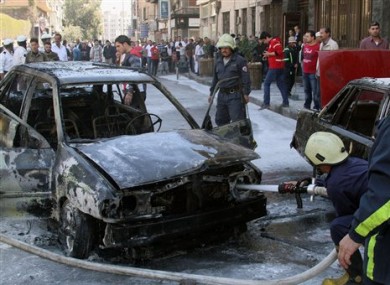Firefighters extinguish a burning vehicle after two mortar rounds struck the Abu Roumaneh area in Damascus, Syria yesterday.