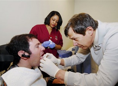 Jason DiSanto, left, receiving a tongue piercing at Georgia Tech in Atlanta. An experimental device is letting paralyzed people drive wheelchairs simply by flicking their tongue in the right direction.