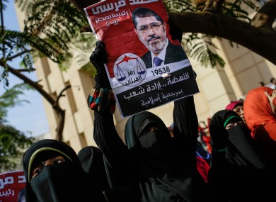 A Morsi supporter holds an old presidential campaign poster during a protest yesterday.