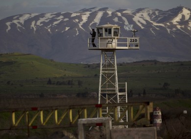 A UN peacekeeper from the UNDOF force stands guard on a watch tower at the Quneitra Crossing between Syria and the Israeli-controlled Golan Heights.