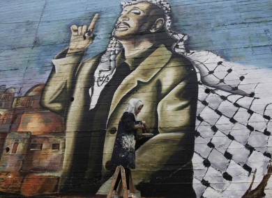 Palestinian Hanadi Kharma paints a mural of Yasser Arafat in the West Bank city of Nablus yesterday.