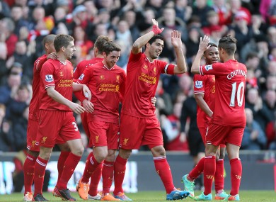 Liverpool's Luis Suarez (centre) celebrates scoring his team's third goal alongside teammates today.